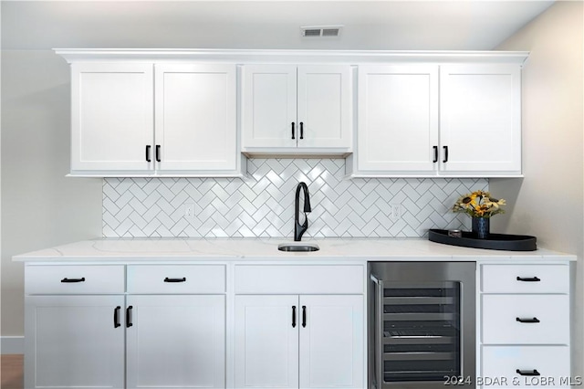 bar with beverage cooler, visible vents, backsplash, and a sink