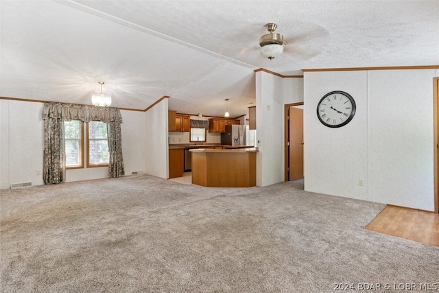 unfurnished living room featuring crown molding, a textured ceiling, vaulted ceiling, light colored carpet, and a chandelier