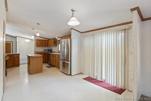 kitchen with lofted ceiling, appliances with stainless steel finishes, a center island, ornamental molding, and decorative light fixtures