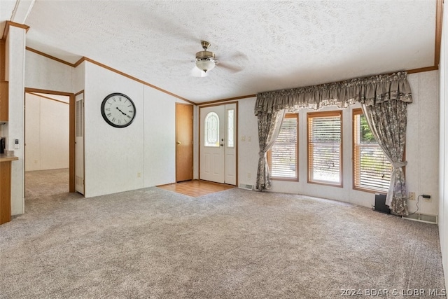 unfurnished living room with ornamental molding, light colored carpet, and a textured ceiling