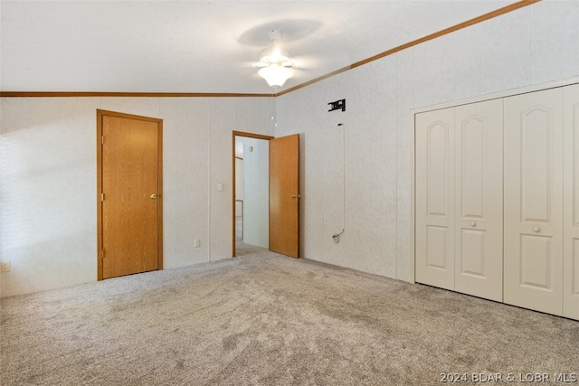 unfurnished bedroom featuring lofted ceiling, crown molding, ceiling fan, and carpet flooring