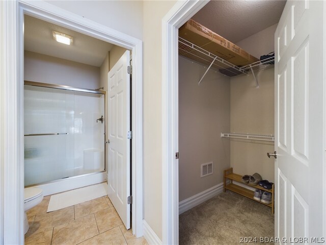 spacious closet featuring light tile patterned floors