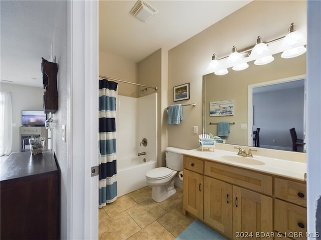 full bathroom with vanity, tile patterned floors, shower / bath combo with shower curtain, and toilet