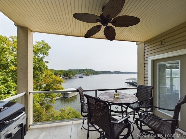 balcony with grilling area, a water view, and ceiling fan