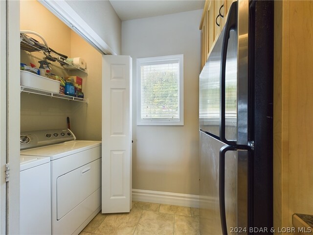 clothes washing area with light tile patterned flooring and independent washer and dryer