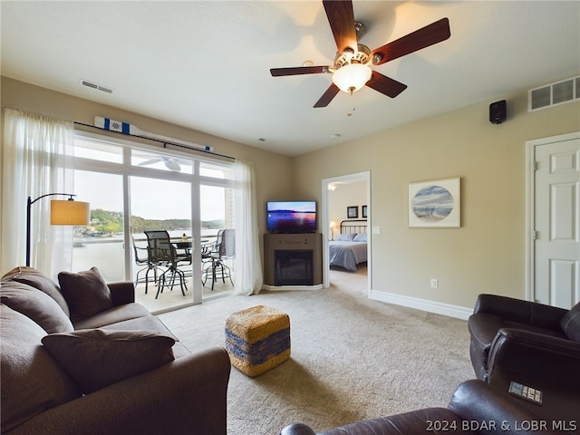 living room with ceiling fan and light colored carpet