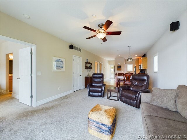 living room featuring light carpet and ceiling fan