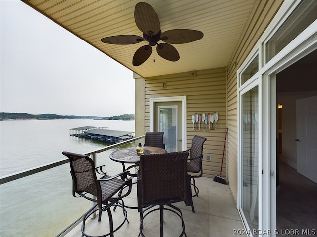 balcony featuring a water view and ceiling fan