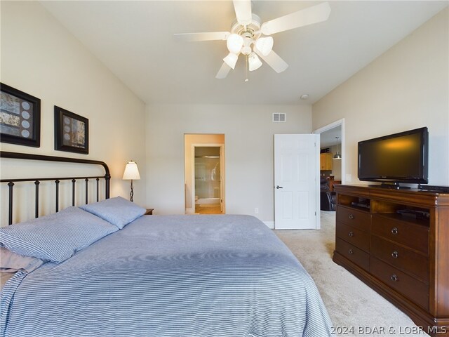 bedroom featuring ensuite bathroom, ceiling fan, and light colored carpet