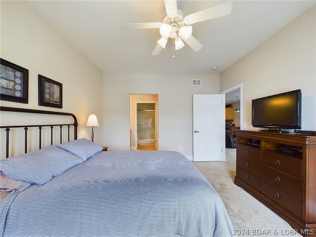 bedroom featuring light carpet, connected bathroom, and ceiling fan