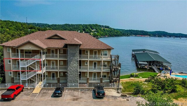 view of building exterior featuring a water view and a pool