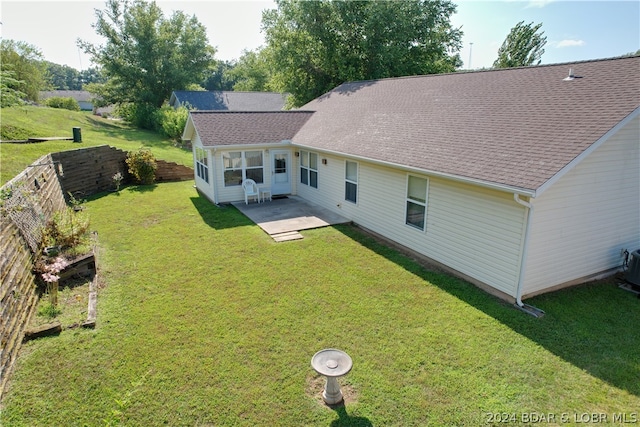 back of property with a yard and a patio area