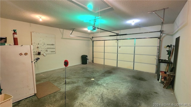 garage featuring a garage door opener and white refrigerator