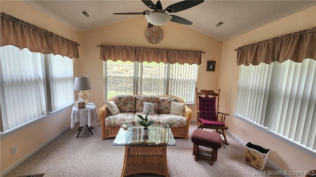 carpeted living room featuring ceiling fan, vaulted ceiling, and a textured ceiling