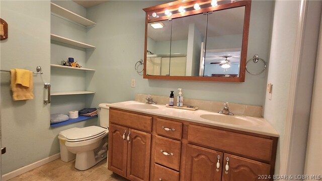 bathroom featuring tile patterned flooring, vanity, a shower with door, and toilet