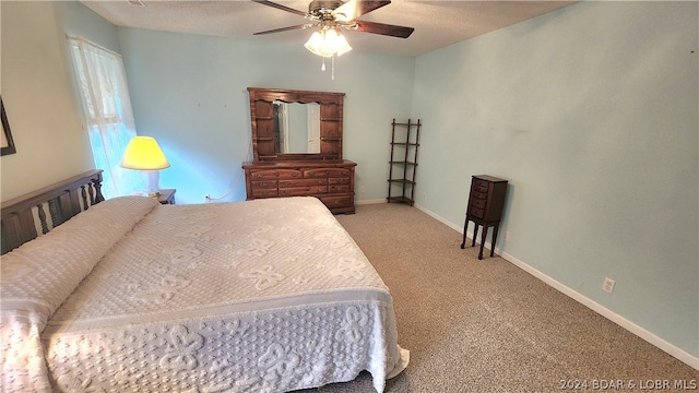 bedroom featuring ceiling fan, light carpet, and a textured ceiling