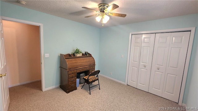 carpeted office space featuring ceiling fan and a textured ceiling