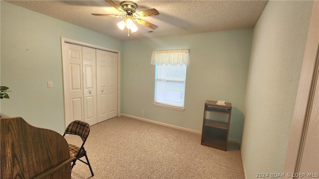 office space with ceiling fan, light carpet, and a textured ceiling