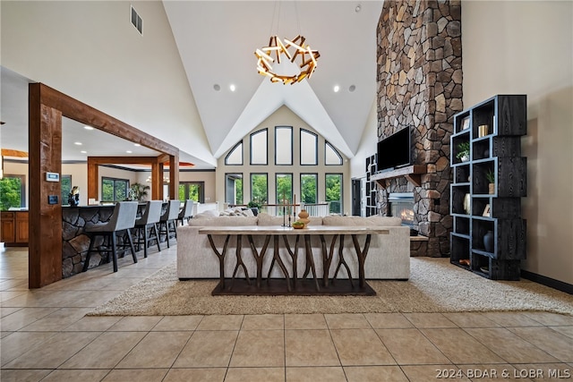 tiled living room featuring high vaulted ceiling and a stone fireplace