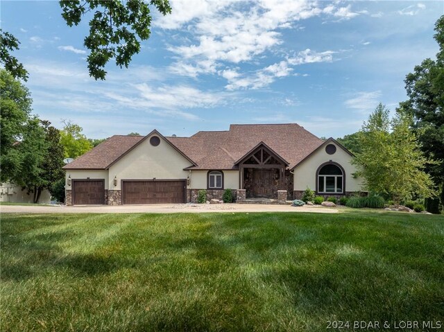 view of front of property featuring a garage and a front lawn