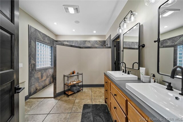 bathroom featuring vanity, tiled shower, and tile patterned floors