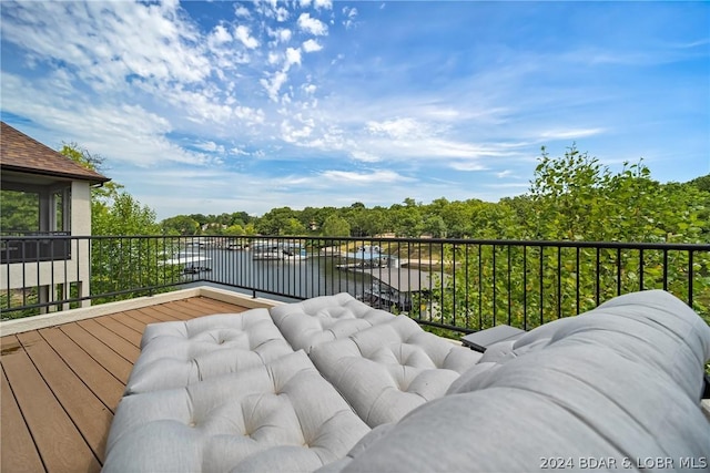 balcony featuring a water view and an outdoor living space