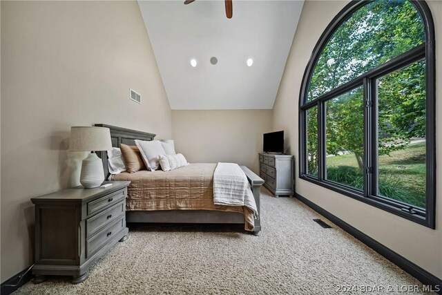 bedroom featuring vaulted ceiling, light colored carpet, and ceiling fan