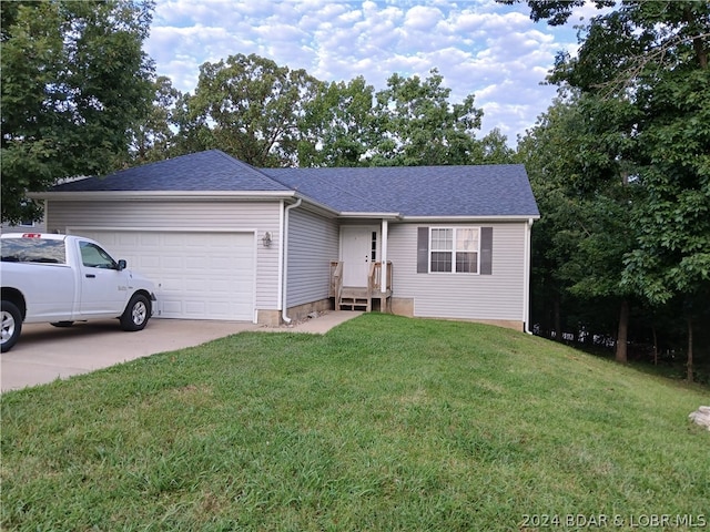 ranch-style house featuring a garage and a front lawn