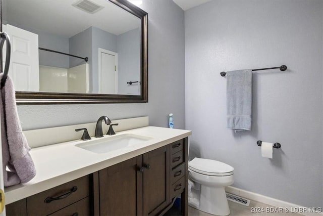 bathroom featuring walk in shower, vanity, and toilet