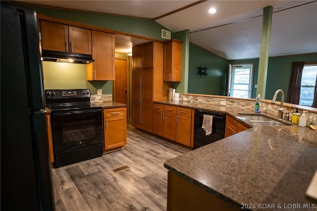 kitchen featuring lofted ceiling, black appliances, sink, kitchen peninsula, and wood-type flooring