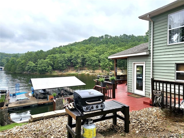 wooden terrace featuring a water view and a dock