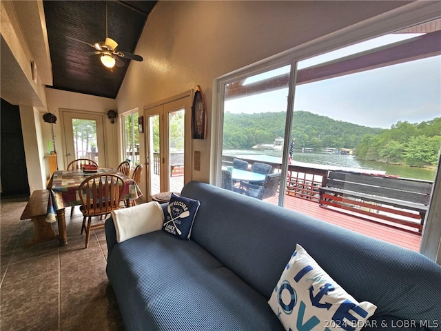 tiled living room with wood ceiling, ceiling fan, a water view, vaulted ceiling, and french doors