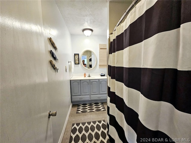 bathroom with vanity, a textured ceiling, and walk in shower