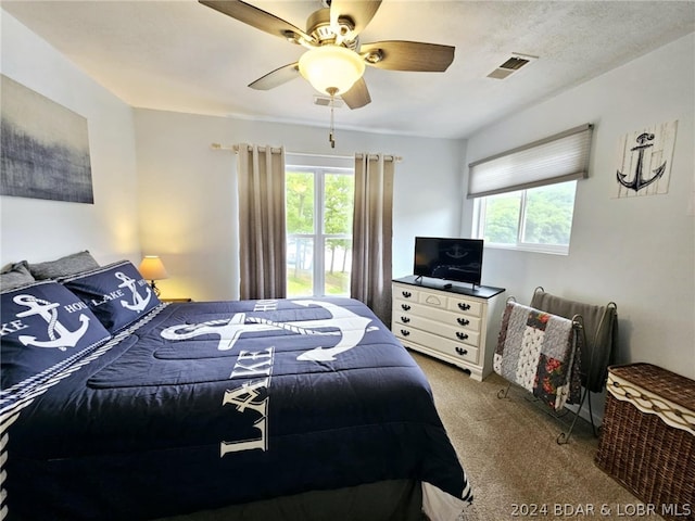 carpeted bedroom featuring a textured ceiling and ceiling fan