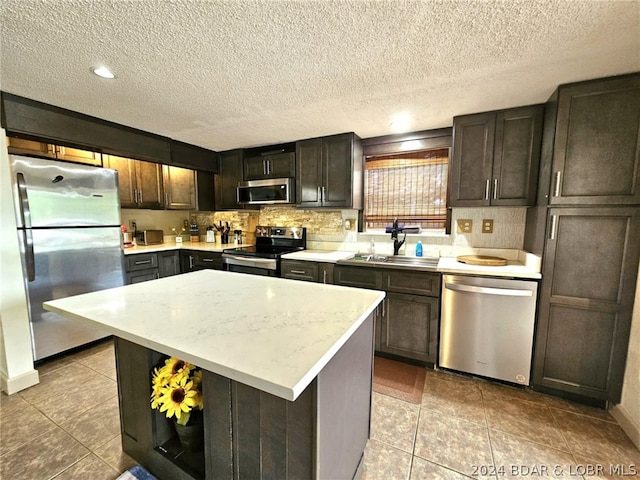 kitchen featuring dark brown cabinetry, sink, a center island, and appliances with stainless steel finishes