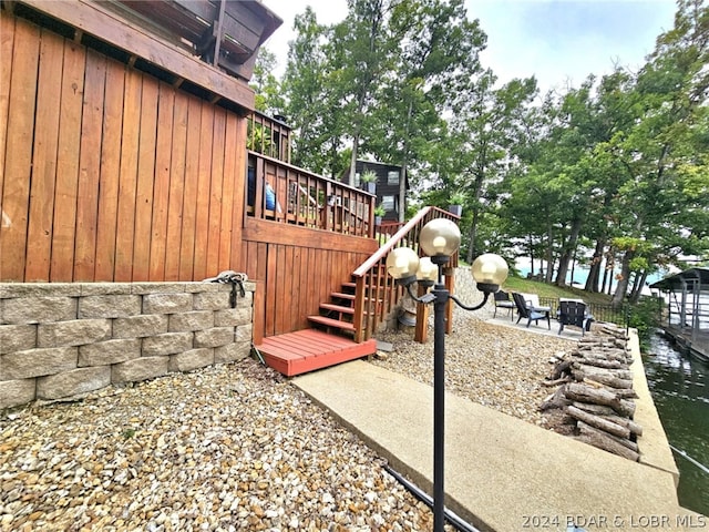 view of yard with a patio and a deck with water view