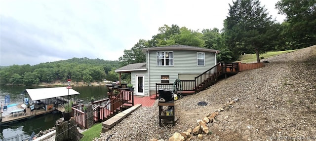 back of property featuring a deck with water view