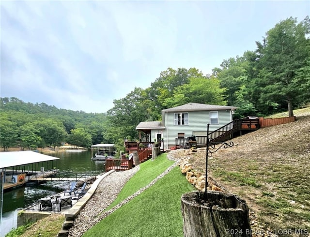 view of yard featuring a water view and a dock