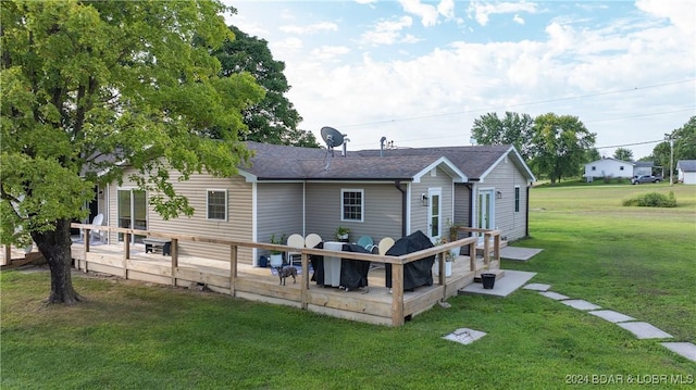 back of property with a wooden deck and a yard