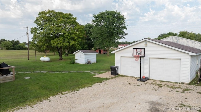 view of yard featuring a garage and a storage unit