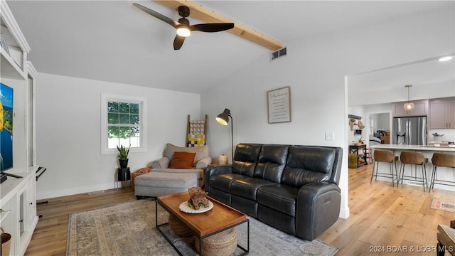 living room with vaulted ceiling with beams, ceiling fan, and light hardwood / wood-style flooring