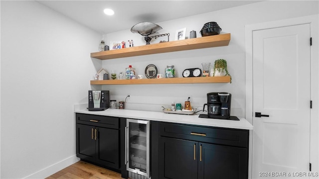 bar featuring wine cooler and light hardwood / wood-style flooring