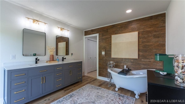 bathroom featuring vanity, a tub to relax in, and wood-type flooring