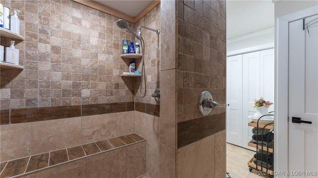 bathroom featuring tile patterned flooring and tiled shower