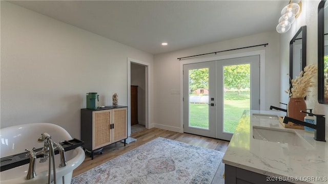 doorway to outside featuring sink, light hardwood / wood-style floors, and french doors