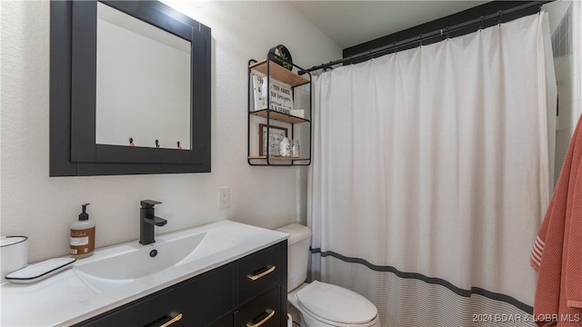 bathroom featuring a shower with curtain, vanity, and toilet