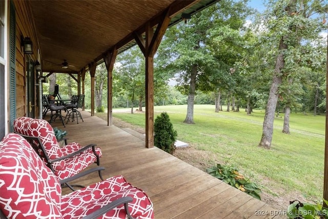 wooden terrace with ceiling fan and a yard