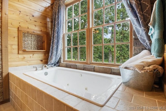 bathroom with a relaxing tiled tub and plenty of natural light