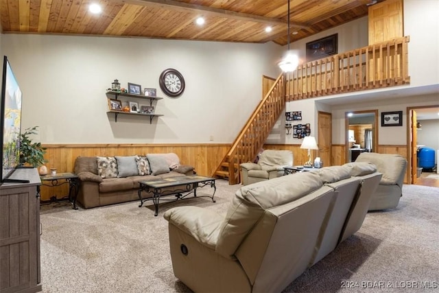 living room featuring a high ceiling, wooden walls, light colored carpet, and wooden ceiling