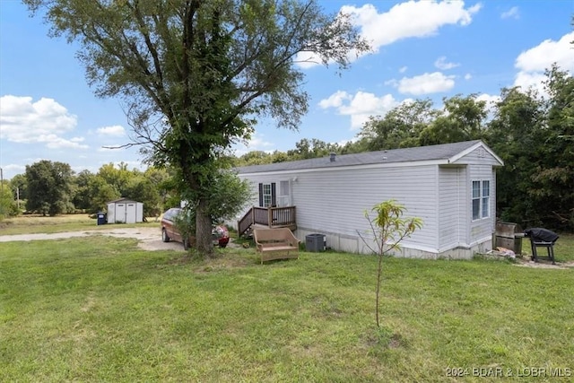 rear view of house with a yard and a storage shed